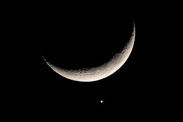Close Up Astronomical Photo of Crescent Moon and Brilliant Venus Conjunction in Black Night Sky