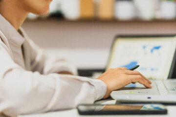 Businesswoman using laptop analyzing growth charts, side view