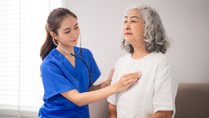 Asian nurse adult woman performs health check on older patient stethoscope medical examination...