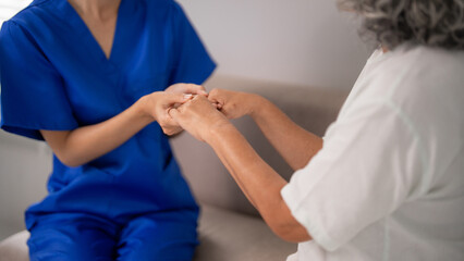 Healthcare worker providing compassionate support to older adult at home building trust showing...