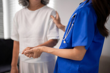 Obraz premium Asian Adult Nurse Tenderly Supports Older Adult Woman Hands Holding Compassionate Healthcare Home Assistance