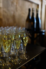 Sparkling drinks are arranged neatly in elegant glasses, preparing for a special celebration at a stylish venue. The atmosphere is festive, inviting guests to enjoy the occasion.