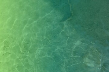 Shallow green ocean water with sunlight ripples, peaceful water texture