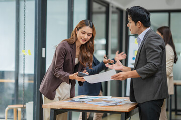 Group of Asian businesspeople sits down for a business investment planning meeting.
