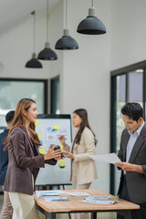 Group of Asian businesspeople sits down for a business investment planning meeting.