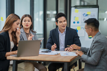 Group of Asian businesspeople sits down for a business investment planning meeting.	