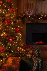 A beautifully lit Christmas tree adorned with red ornaments stands beside a fireplace. Colorful gifts are wrapped and placed nearby, enhancing the festive ambiance of the room.