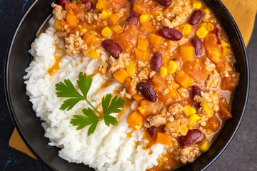Chili con carne with rice in a black bowl