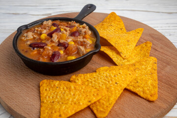 Chili con carne in a skillet with triangular nachos
