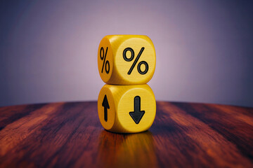 A Close-Up Photograph of Two Bright Yellow Dice Stacked with Percentage and Up/Down Arrow Symbols