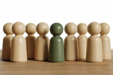 A Minimalist Composition of Wooden Peg People Figures Standing in a Group with a Single Green Leader in the Center