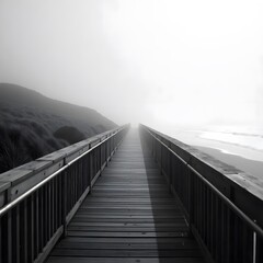 Obraz premium Long Wooden Boardwalk Path Extends Into Dense Fog at Serene Coastal Beach with Ocean Waves