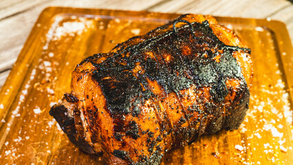 Whole pork chashu roll on a wooden board, perfectly toasted and golden brown outside. Ready to slice for ramen bowls. Marinated, tender, and aromatic.