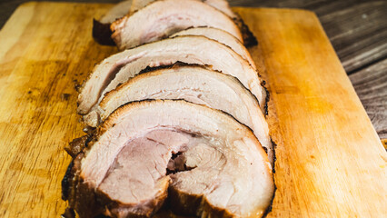 Sliced rolled pork belly chashu arranged on a wooden board, ready for ramen. Tender, marinated, and perfectly cooked. Ideal for Asian cuisine and food presentation.