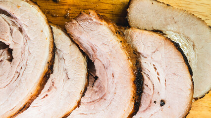 Sliced rolled pork belly chashu arranged on a wooden board, ready for ramen. Tender, marinated, and perfectly cooked. Ideal for Asian cuisine and food presentation.