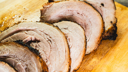 Sliced rolled pork belly chashu arranged on a wooden board, ready for ramen. Tender, marinated, and perfectly cooked. Ideal for Asian cuisine and food presentation.
