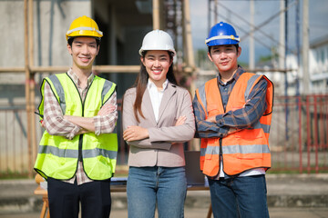Confident construction team standing with arms crossed at an active jobsite.