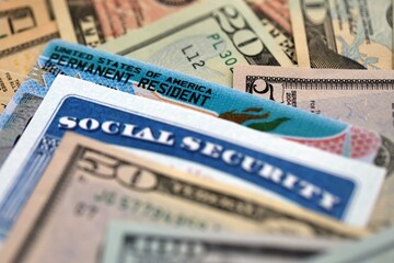 Social security number and permanent resident card with US dollar money bills close up
