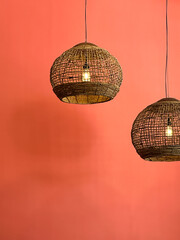 Woven Rattan Pendant Lights Against Coral Wall