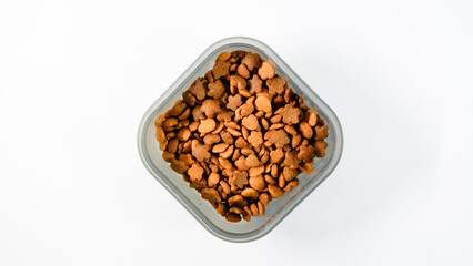 Flat lay view of Dry pet food, cat kibble pile in gray plastic bowl isolated on white background