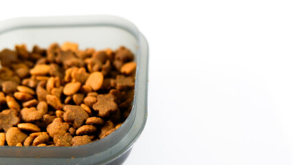 Dry pet food close up, cat kibble pile in gray plastic bowl isolated on white background