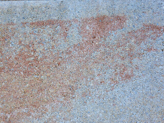 Close up flaking masonry revealing speckled pigments and pitted granular surface in warm