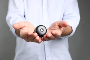 Man with hidden spy camera on grey background, closeup