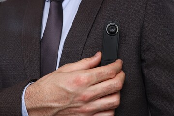 Businessman with modern hidden spy camera, closeup