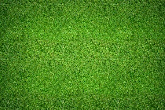 Green grass field background top view texture - aerial of a large patch of some freshly cut, healthy, green grass lawn for sports pitch.