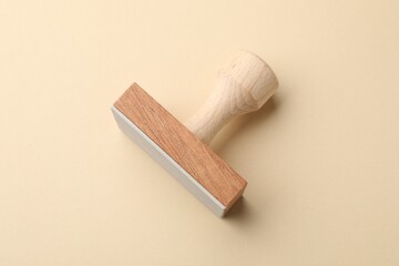 One wooden stamp on beige background, top view