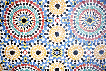 Colorful geometric tile pattern featuring intricate circular designs in vibrant hues of red, yellow, green, and blue, showcasing traditional craftsmanship and artistic expression