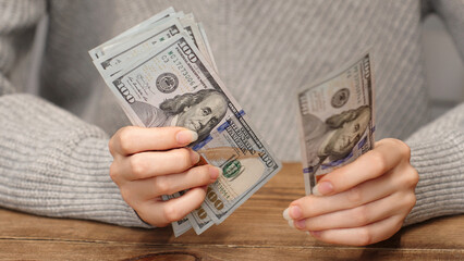 Woman counting 100 US dollar bills. Cash calculation concept for personal finance, salary or...