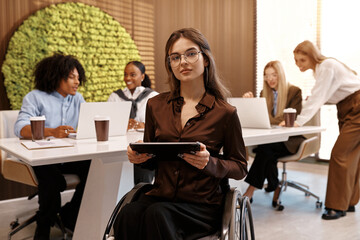 Confident disabled woman using tablet in inclusive modern office