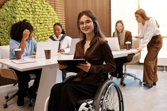 Confident disabled woman using tablet in inclusive modern office