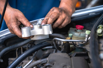 Close up unknown auto mechanic with tool fixing car in auto repair shop