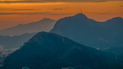 Oct 26 2025 Golden Sunset Over Mountain Ranges With City Skyline Beneath