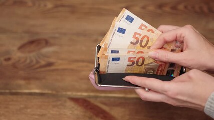 Woman counting euro banknotes in a wallet. Cash payment or savings concept for personal finance. Ideal for budgeting, planning investment, financial education content. Financial background. Copy space - Powered by Adobe