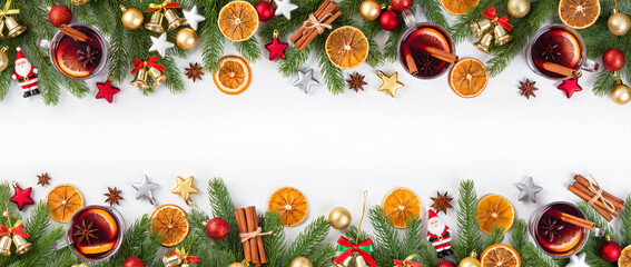 Christmas frame with mulled wine, fir branches, dried oranges, cinnamon, anise stars, and festive decorations on white background.
