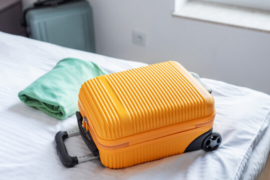 Travel suitcase on hotel bed preparing for journey