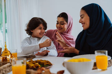Muslim family members playing a game during eid celebration meal