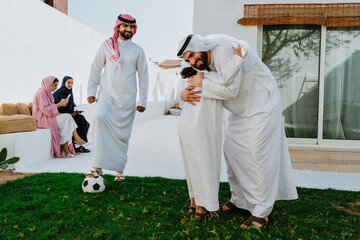 Arab family playing soccer together in backyard
