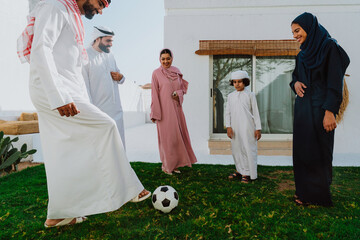 Arab family playing soccer together outdoors