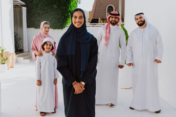 Emirati family standing together smiling in traditional attire