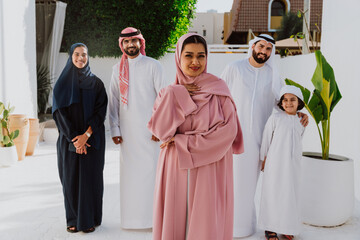 Emirati family standing together smiling in traditional attire