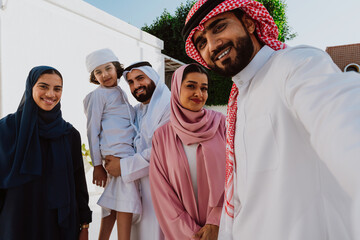 Emirati family standing together smiling in traditional attire