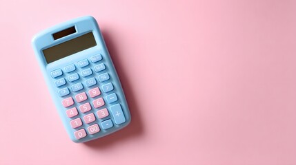 Pastel colored electronic calculating device rests diagonally on a plain pink background viewed from above