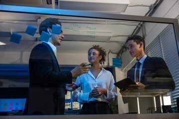 Businessman and businesswoman corporate professional brainstorming , discussing ideas, innovation technology, and writing on glass board in modern office