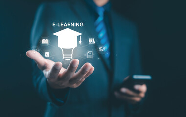 Businessman holding virtual e-learning icon with education symbols, representing online learning, digital education, innovation, and knowledge sharing in modern technology.