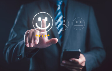 Businessman using smartphone to give five star rating with happy face icon, representing customer satisfaction, feedback, online review, and service quality evaluation concept.