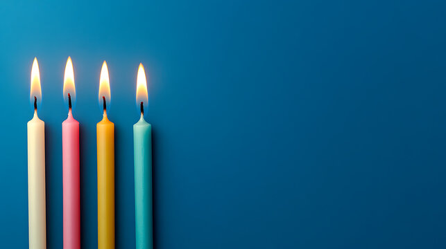 Four colorful candles stand tall, flames flickering against a serene blue background. Warm light meets cool tones in this minimalist composition, a symphony of colors and light. - Powered by Adobe